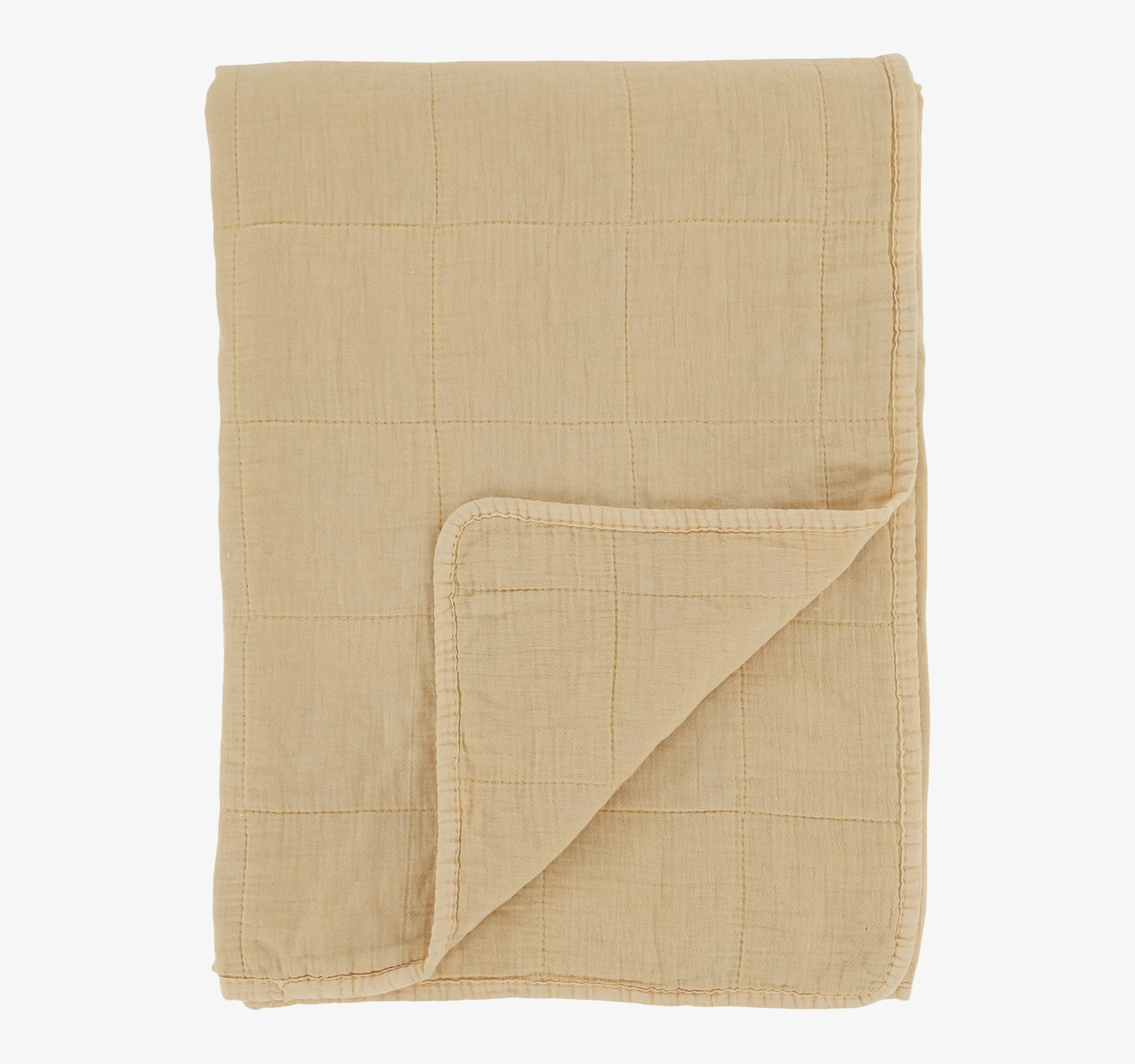 Bild av en quiltad pläd i mjuk melonton, inredning