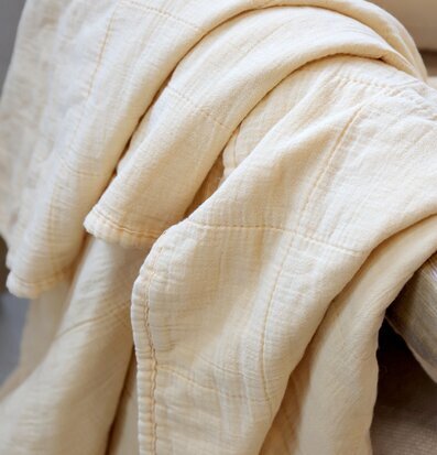 Bild av pläd i melongult som skapar värme och stil