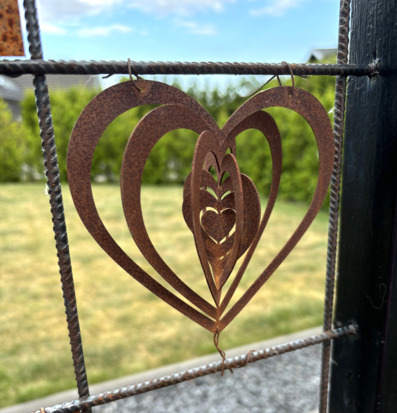 Foto av dekorativ skylt med hjärta i trädgårdsmiljö