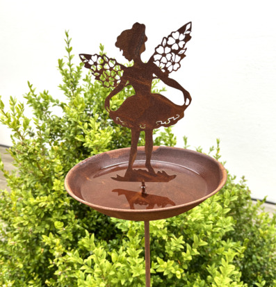 Bild av dekorativt fågelbad med älvamotiv i trädgård