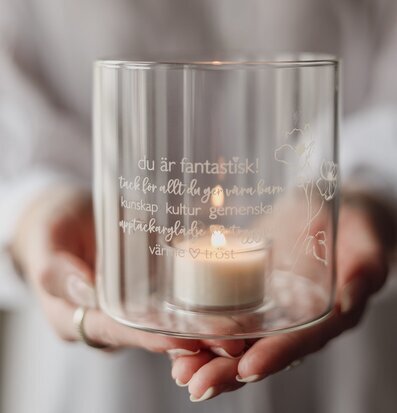 Bild av stilren ljuslykta med gravyr och värmande sken