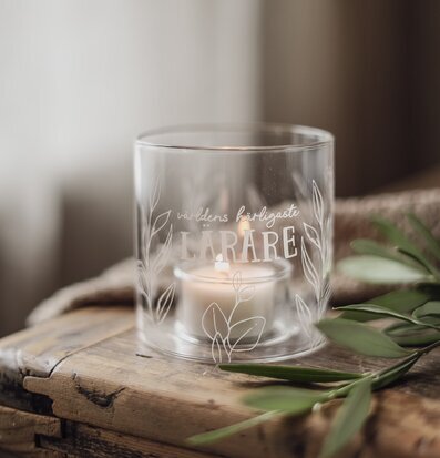 Bild av ljuslykta med text, glas och trä i harmonisk miljö