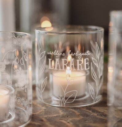 Bild med ljuslyktor och värmeljus på rustikt träbord hemma