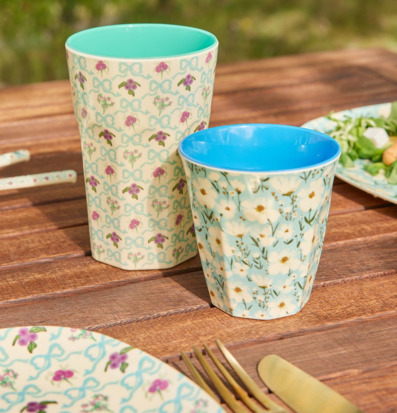 Bild av somrig dukning med färgglada melaminmuggar utomhus