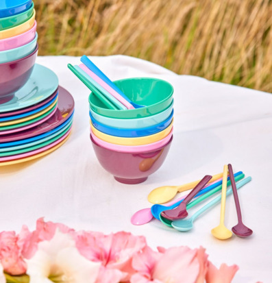 Bild av färgglada melaminskålar och skedar på sommarbord