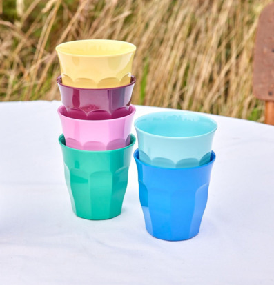 Bild med färgglada stapelbara melaminmuggar utomhus