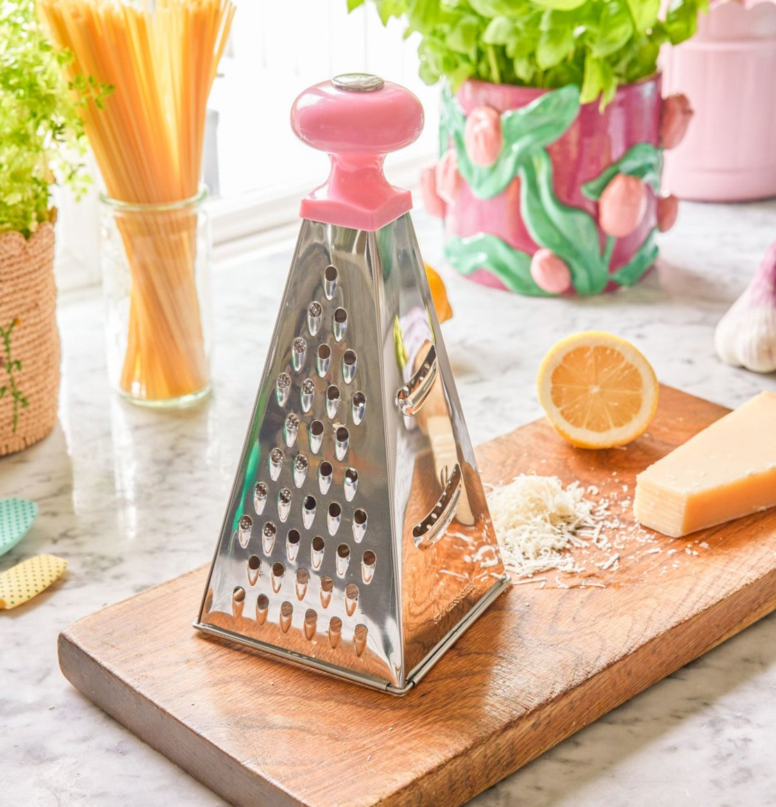 Bild av ljust kök med rivjärn, ost och färska råvaror