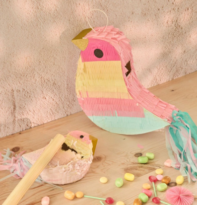 Bild av färgglad fågelpiñata och godis i festlig miljö