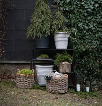 Bild av harmonisk uteplats med grå krukor, korgar och mossa