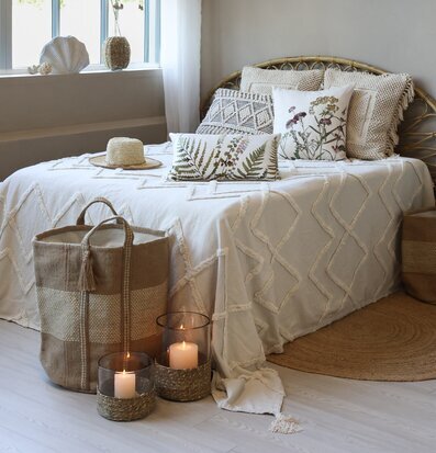 Bild: Sovrum med naturmaterial, botaniska kuddar och jute