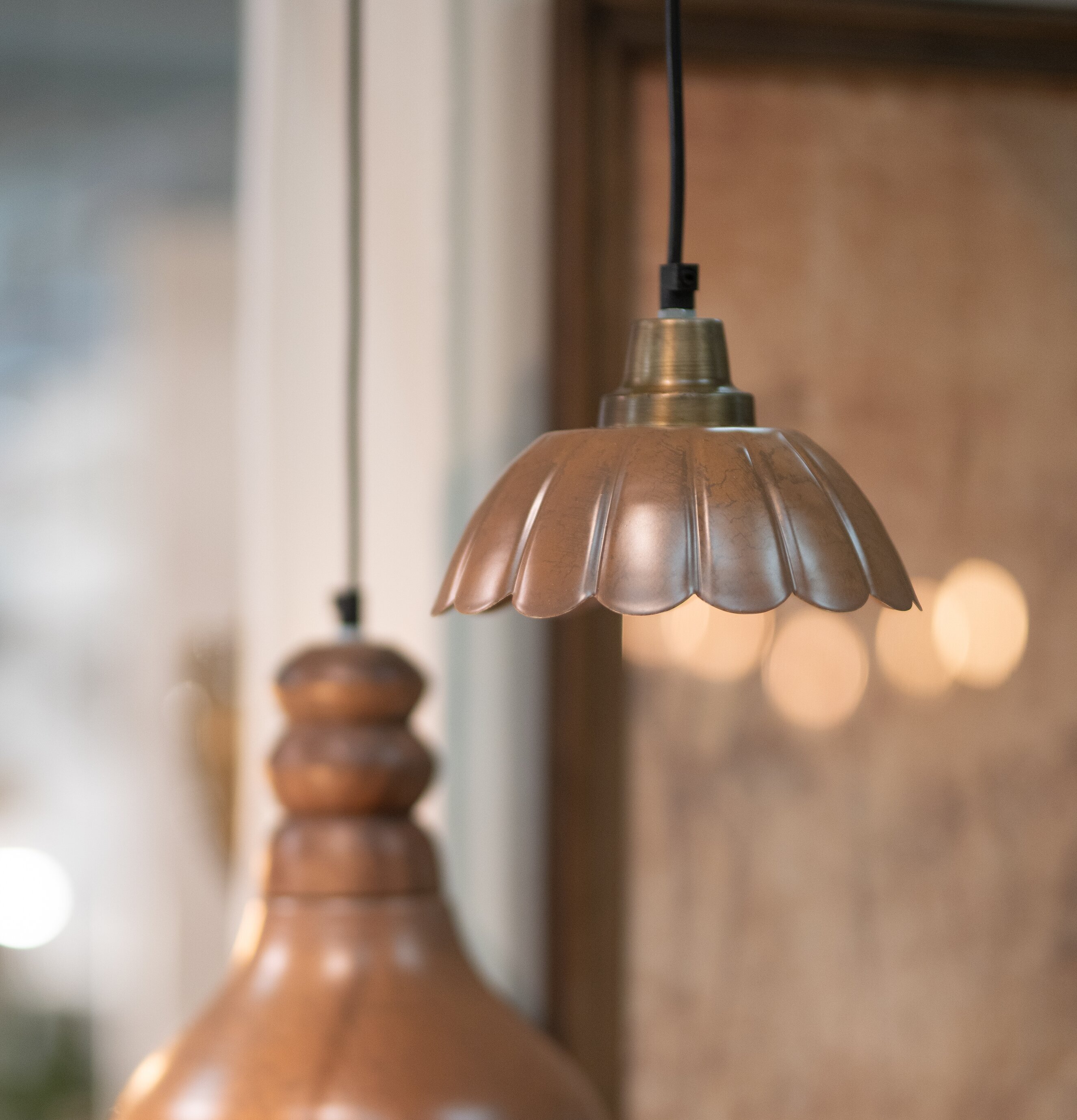 Bild av två taklampor i varm lera och koppar med mjuka former