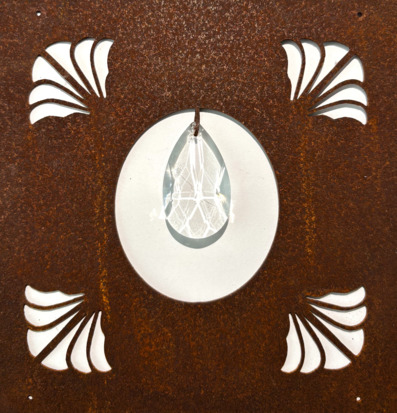 Bild på dekorativ skylt med glasdroppe och snäckmönster