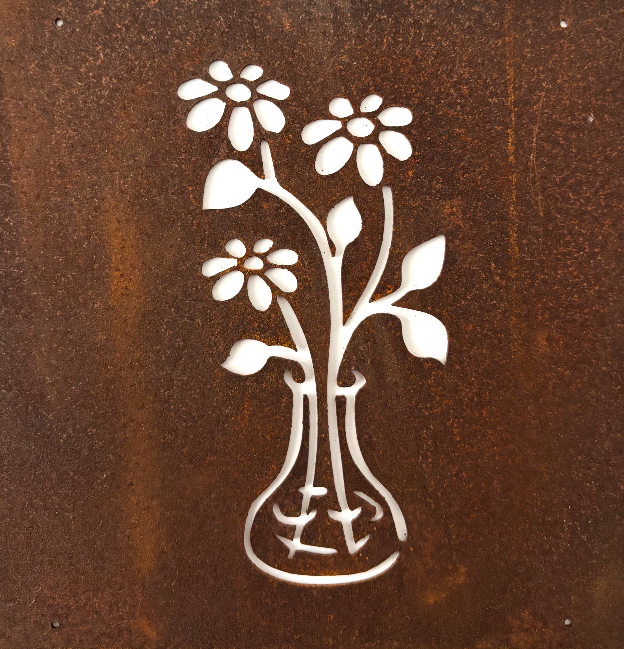 Bild av dekorativ skylt med blommor i vas i rostbrun metall