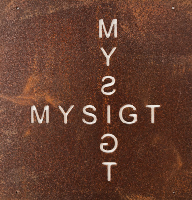 Bild av rostig metallskylt med korsordsmönster och text Mysigt