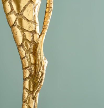 Bild på unik golvlampa med gyllene struktur och grön bakgrund