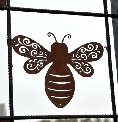 Bild av dekorativ humle i rostig metall mot armeringsnät