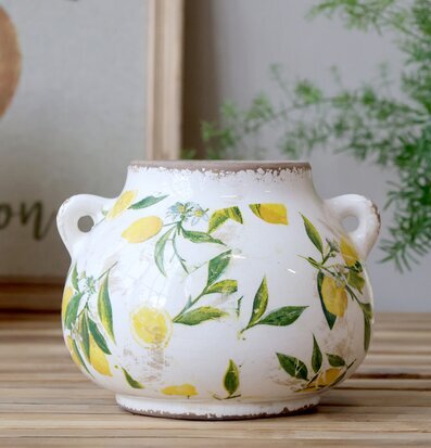 Bild med citronmönstrad kruka i ljus och hemtrevlig miljö