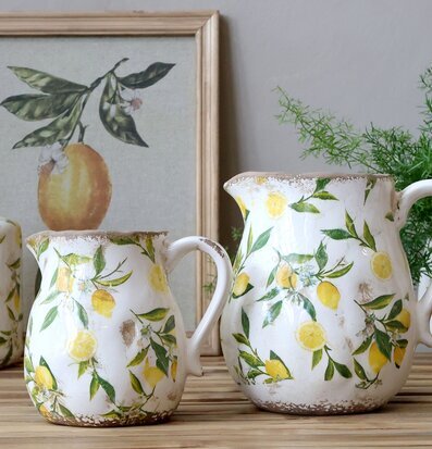 Bild med uppdukning av kannor och citrusmönstrat porslin