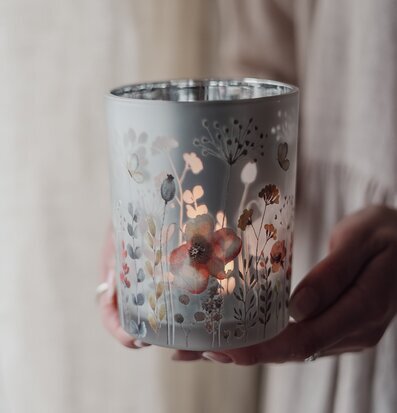 Bild av lykta med blommor och varmt sken för heminspiration