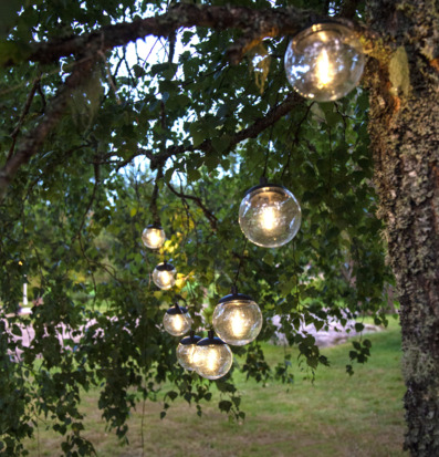 Bild: Stämningsfull solcellsslinga i lummig trädgårdsmiljö