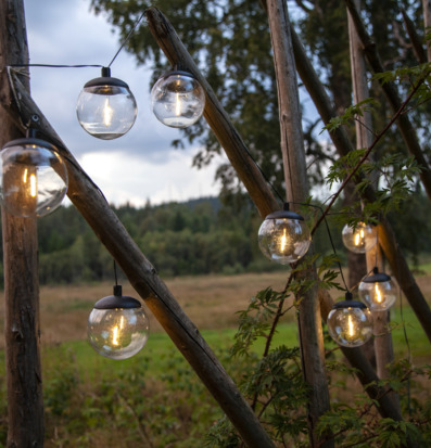 Bild av solcellsdriven ljusslinga i harmonisk naturmiljö