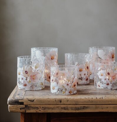 Bild av ljuslyktor med blommor och fjärilar på rustikt träbord