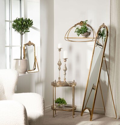 Bild på harmoniskt rum med ljus, grönska och gyllene detaljer