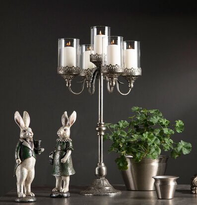 Bild med elegant kandelaber, kaniner och silverdetaljer