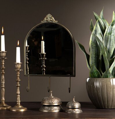 Bild på harmonisk inredning med spegel, ljusstakar och växt