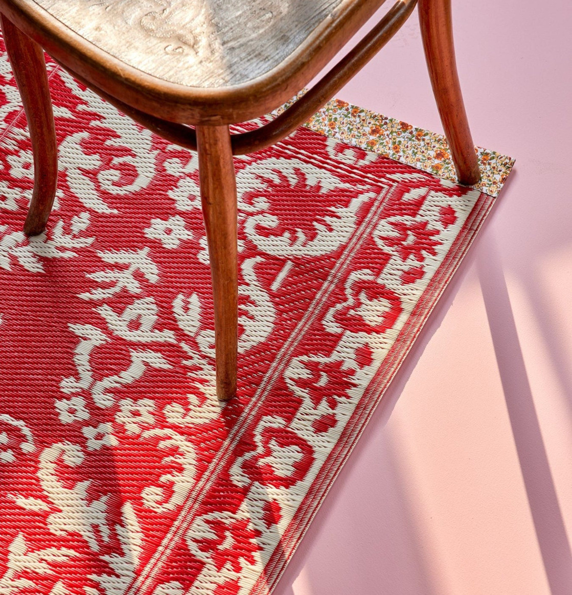 Bild av röd och elfenbensvit plastmatta i ombonat rum