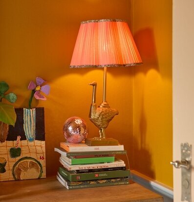 Bild av färgstark inredning med unik lampa och bokstapel