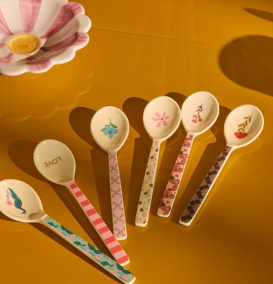 Bild av sex pastellmönstrade teskedar på gult underlag