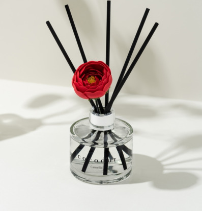 Bild på stilren doftpinne med röd blomma i modern inredning