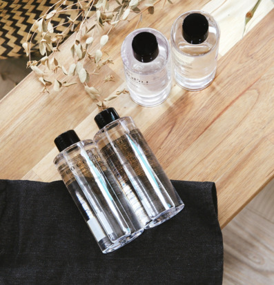 Bild med transparenta plastflaskor på träbord i mjukt ljus