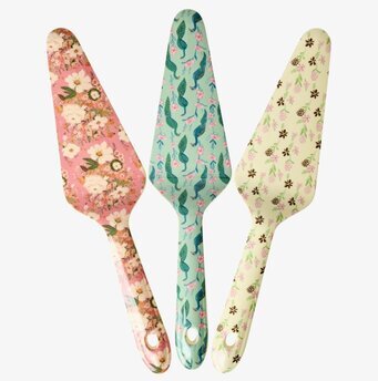 Bild på tre färgglada tårtspadar med blommor och påfåglar