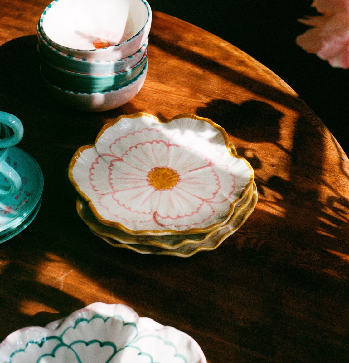 Bild av färgglad keramikdukning med blomformade assietter