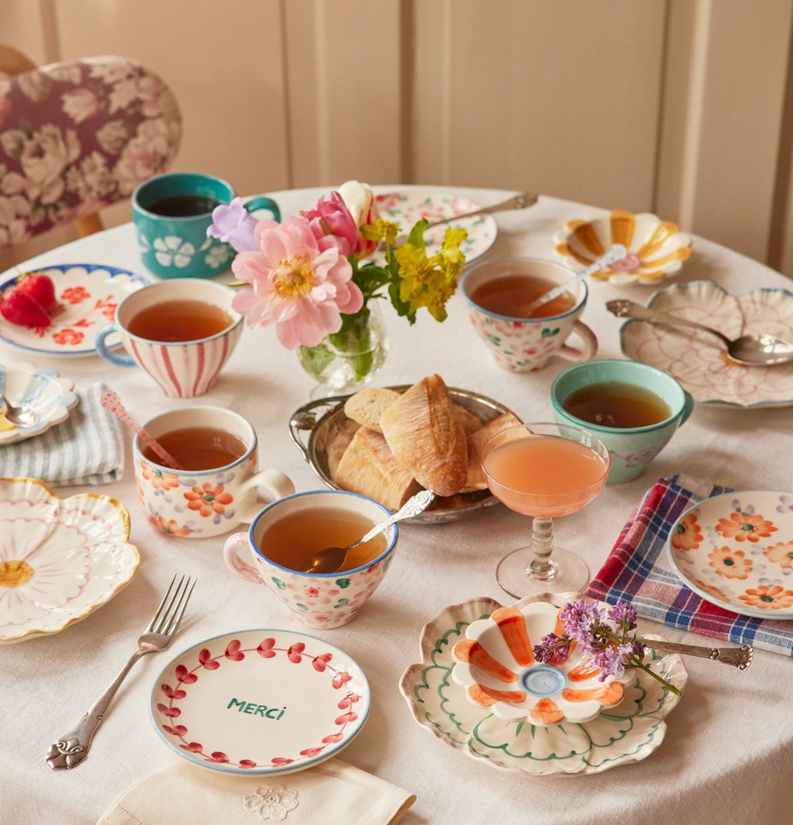 Bild av färgglad kaffedukning med blommig keramik och fika