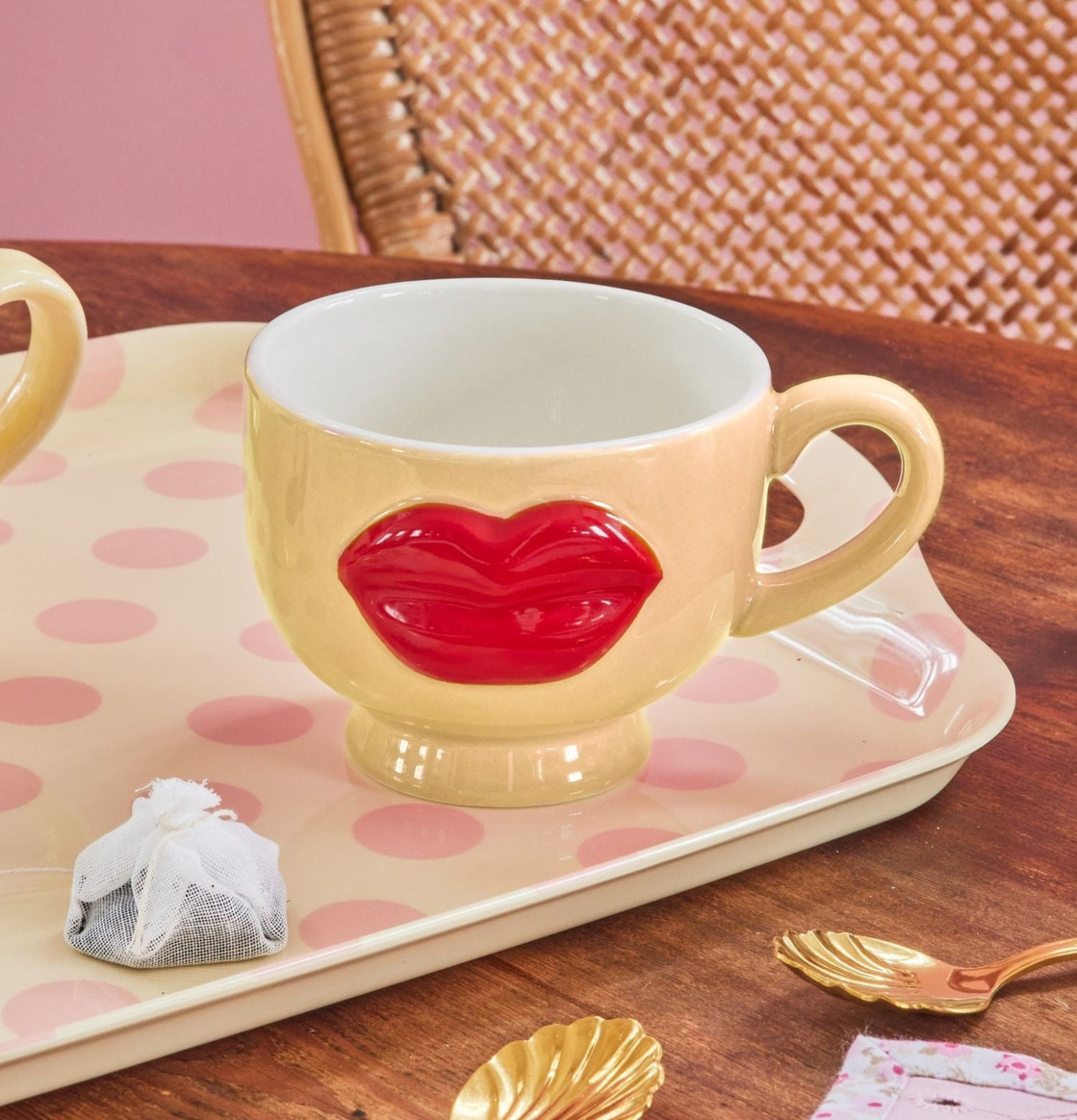 Bild av färgglad kopp och bricka i hemtrevlig fikamiljö