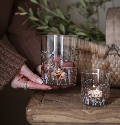 Bild av höstiga ljuslyktor i glas på rustikt träbord hemma