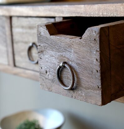 Bild på rustik hylla med tre lådor i trä och metallhandtag