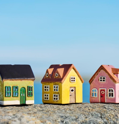 Bild av färgglada keramikhus på solig sten vid havet