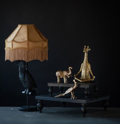 Bild med eleganta djurfigurer och lampskärm i varm guldton