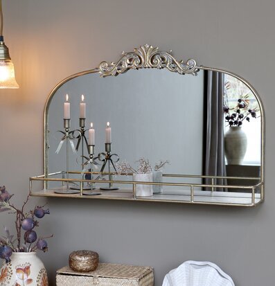 Bild av väggspegel med hylla i antik mässing och varm miljö