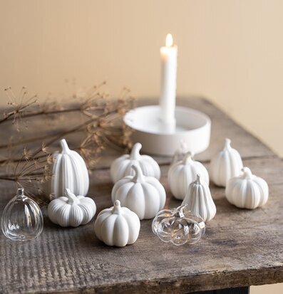 Bild av stilleben med vita keramik- och glaspumpor på träbord