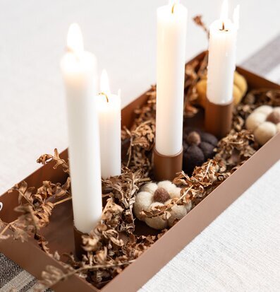 Bild: Varm borddekoration med ljusstake och naturmaterial
