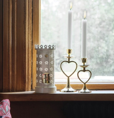 Bild av mysigt fönster med ljusstakar och värmeljushållare