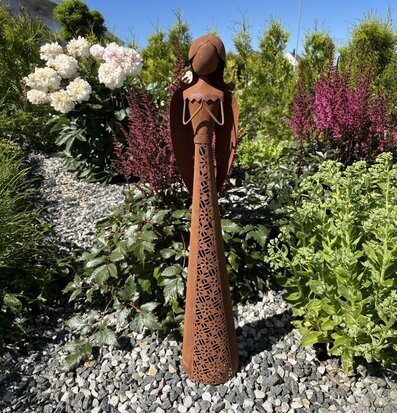 Bild av rostfärgad trädgårdsängel bland blommor och grönska