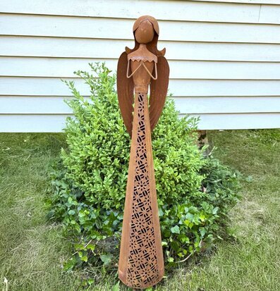 Bild av rostig ängel i trädgård – stilren dekoration utomhus