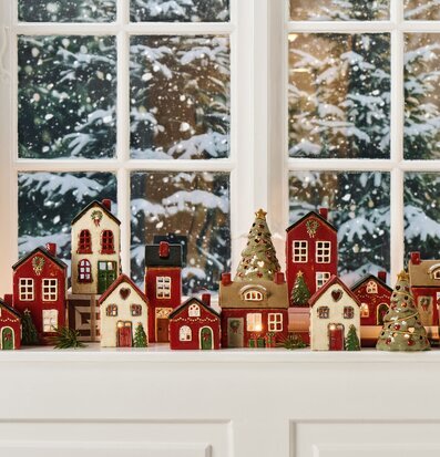 Bild av juliga ljuslyktor i vinterlandskap på fönsterbräda