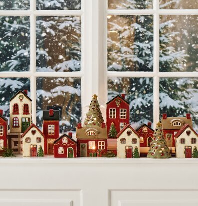 Bild av stämningsfull vinterdekor med ljuslyktor och minihus